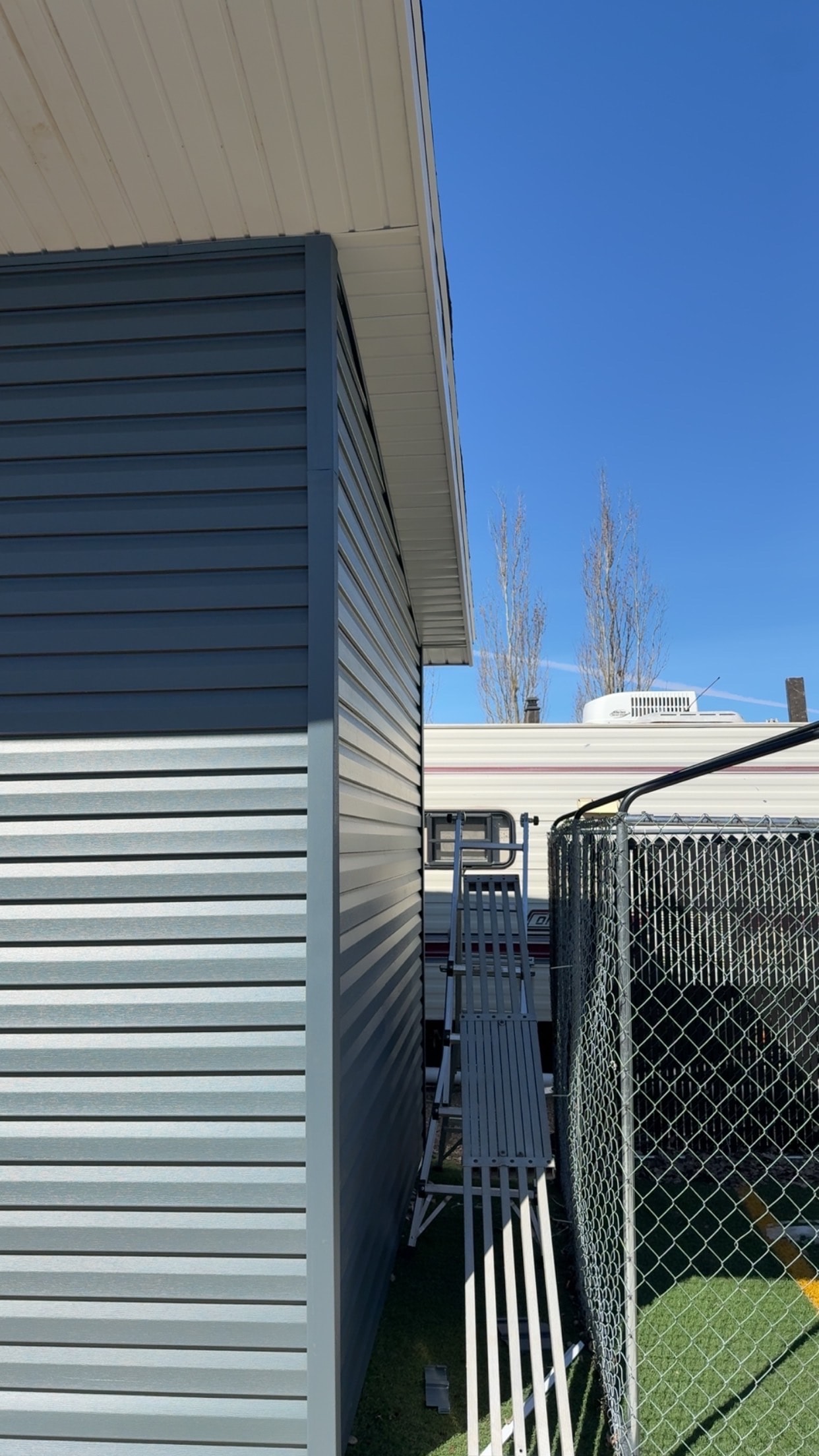 Blue-grey vinyl siding corner detail with soffit Regina